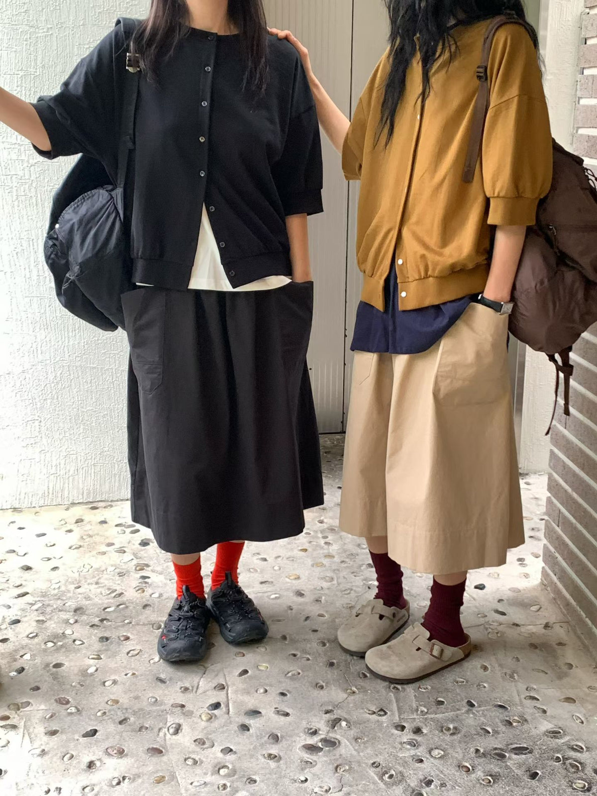 Side-by-side styling of H62 black and brown button-front jackets, showing round necklines, dropped shoulders and banded hems.