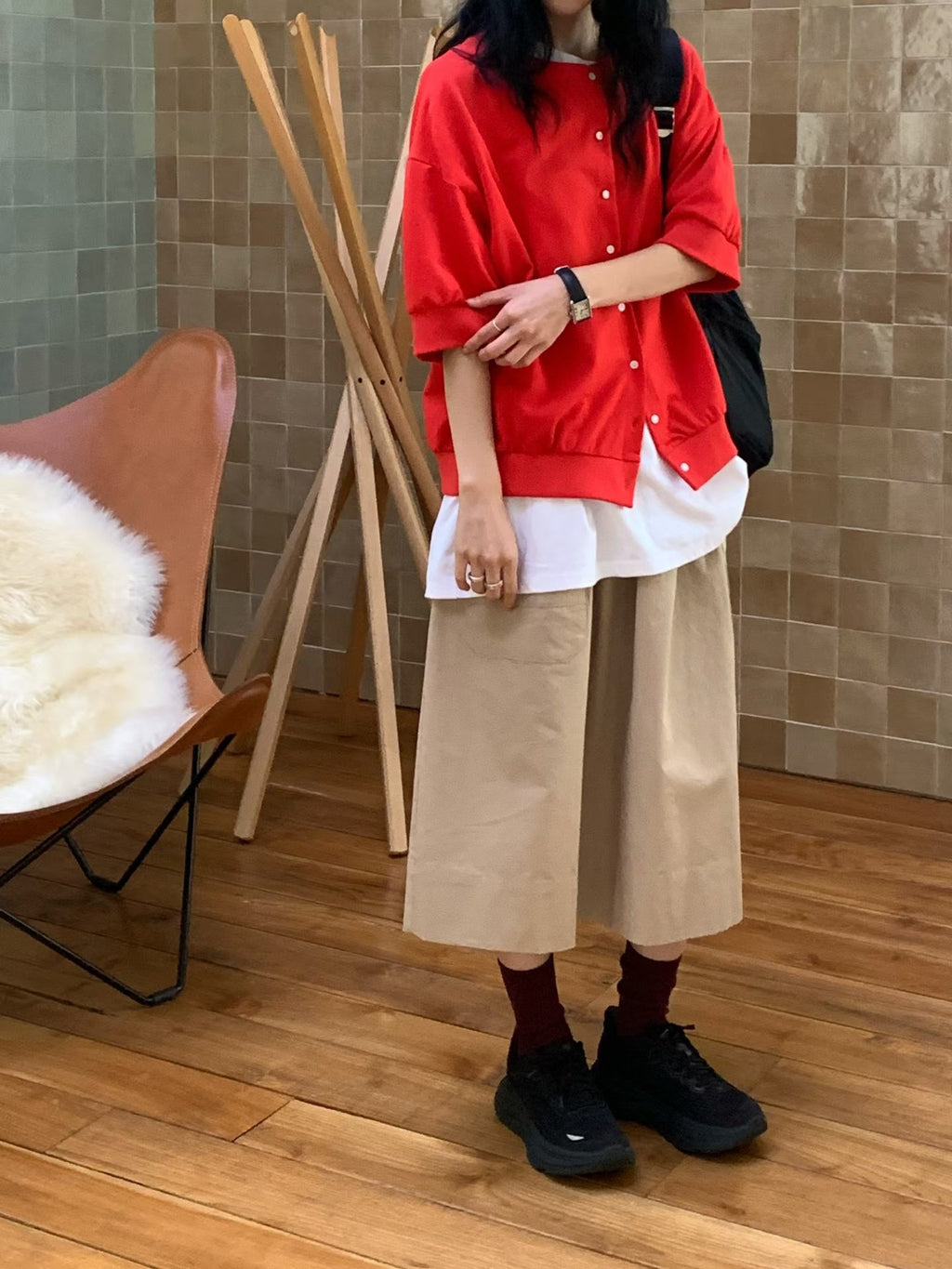 H62 red jacket with the front mostly buttoned, showing relaxed half-length sleeves and a banded hem over a longer white T-shirt.